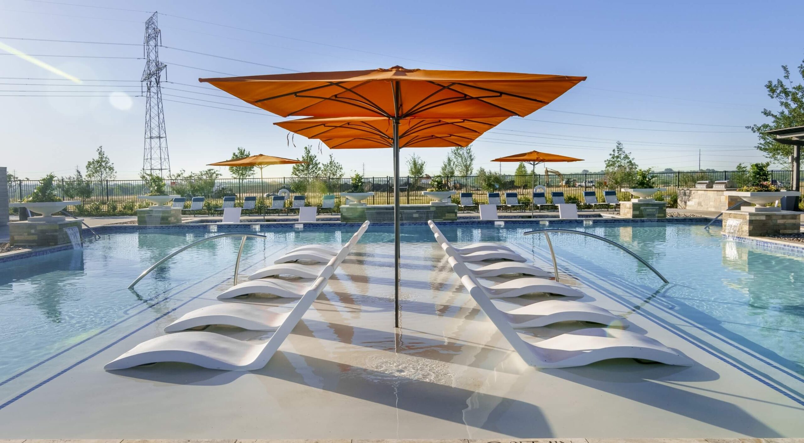 A family-friendly pool with chairs and umbrellas in the Goodland Community.