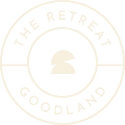 Logo of "the retreat at Goodland" featuring a stylized spartan helmet inside a double-ringed circle with text, representing new homes in Goodland TX.