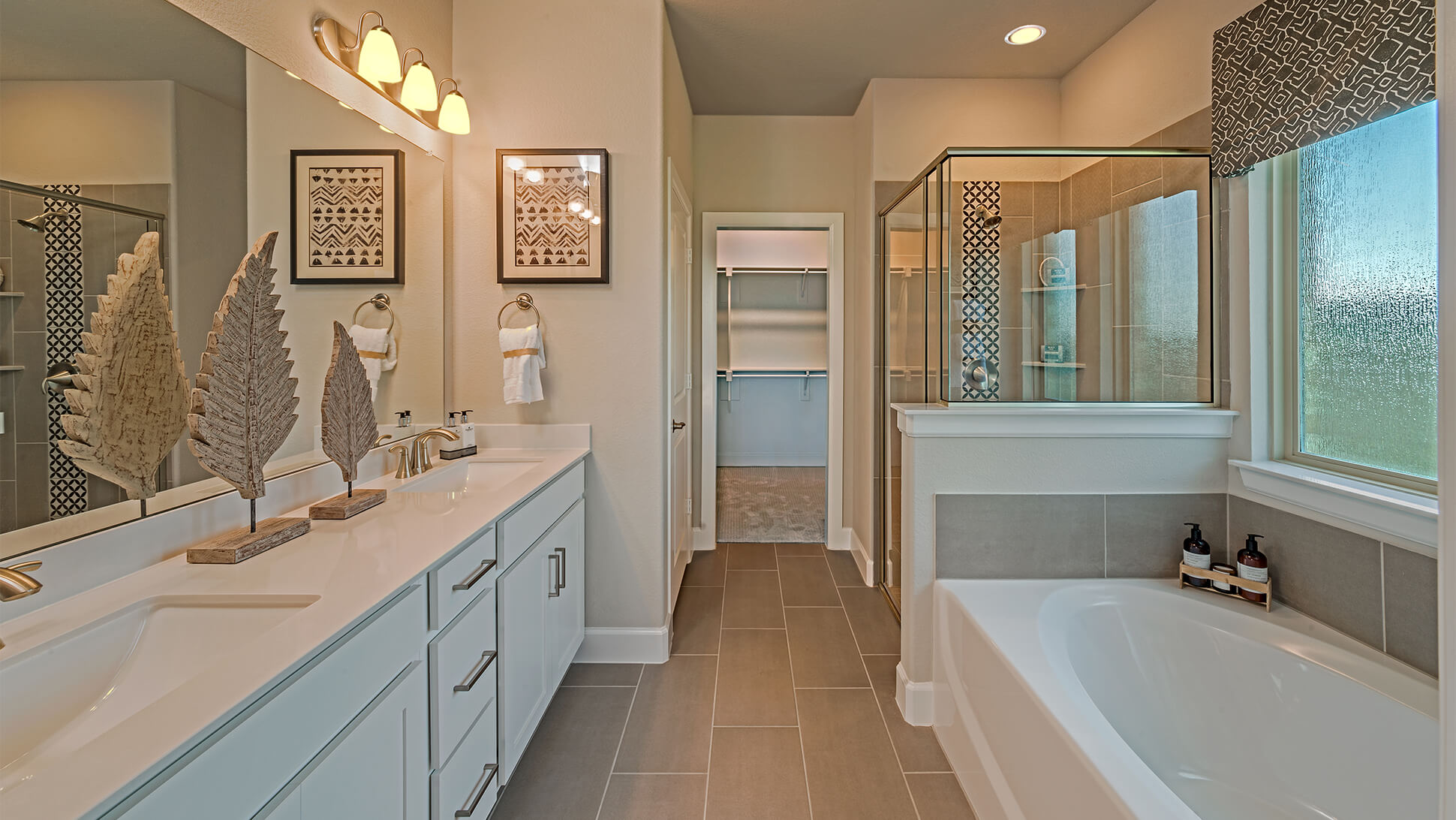 A modern bathroom in new homes in Mansfield, TX, with a dual vanity, bathtub, and a separate shower area.