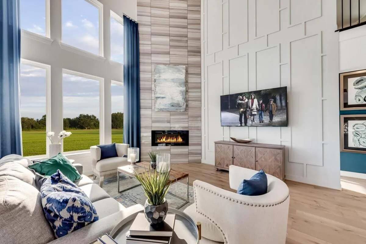 Spacious living room with modern decor, a fireplace, and a view of the outdoors in new homes in Goodland TX.