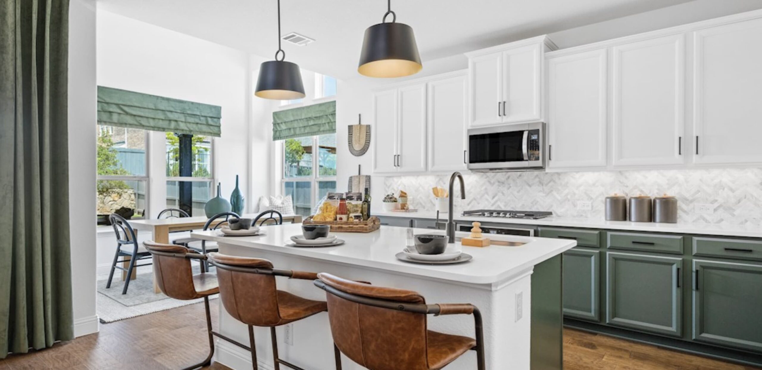 Modern kitchen in new homes in Goodland TX with white cabinets, green accents, and bar-style seating.