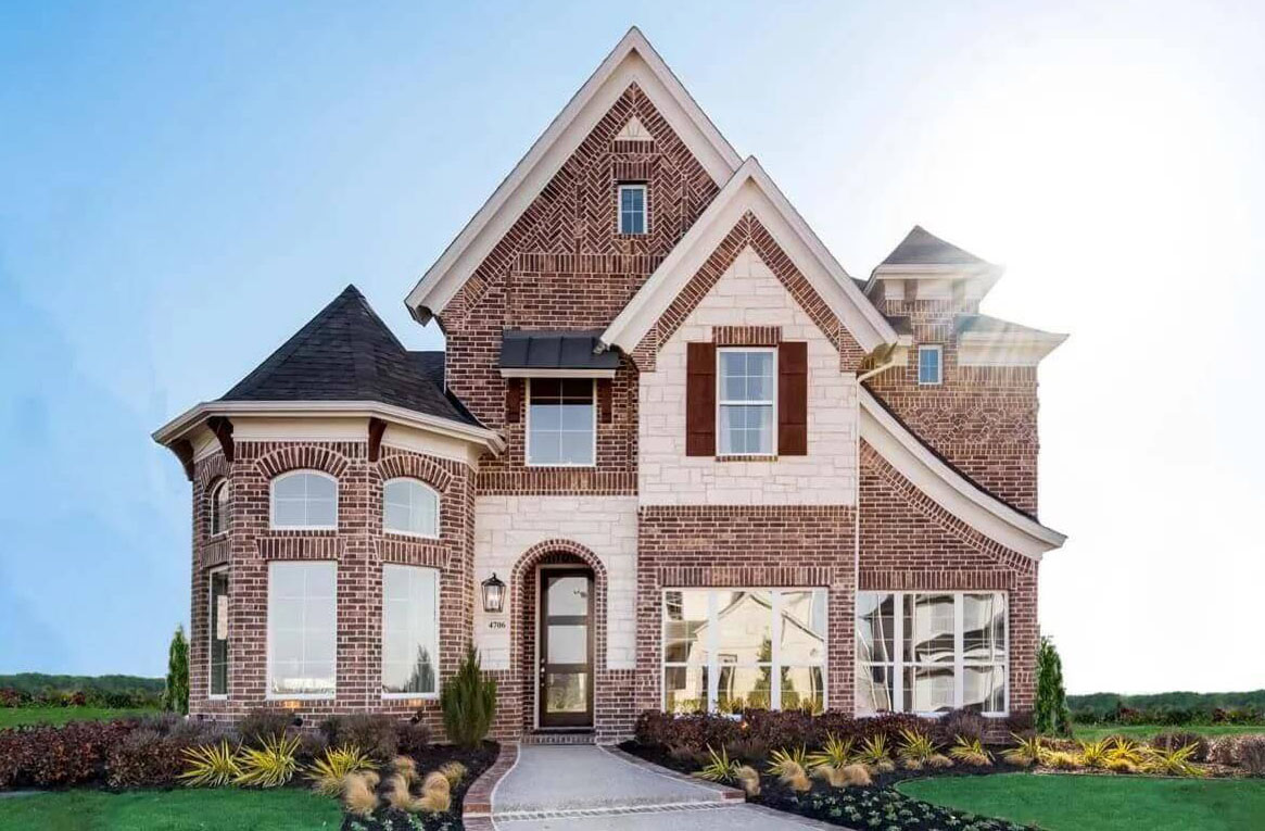 New two-story brick house with landscaped front yard at dusk in Goodland, TX.