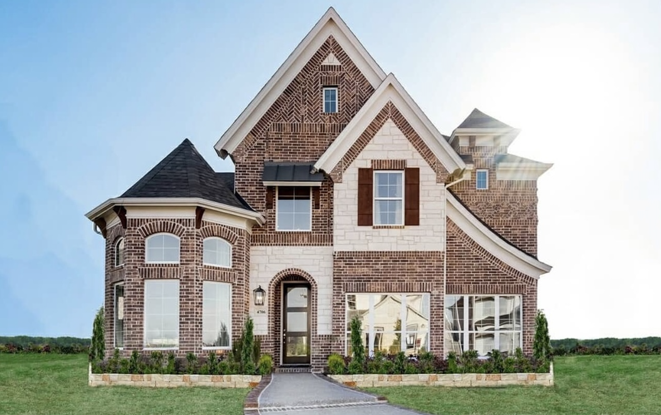 New two-story brick house in new home communities in Mansfield, TX, with a landscaped front yard.